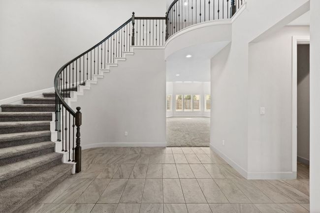 Entrance foyer with baseboards, stairs, carpet floors, and a towering ceiling | Image 4