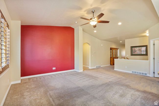 Unfurnished living room featuring visible vents, arched walkways, ceiling fan, and vaulted ceiling | Image 8