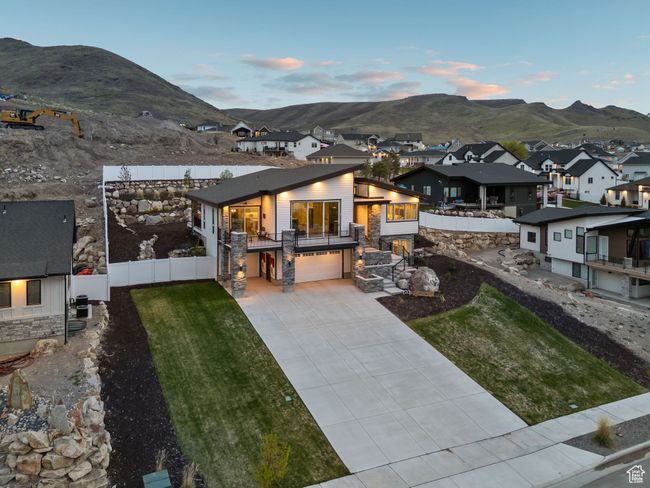 Exterior space with concrete driveway, a balcony, a mountain view, an attached garage, and fence | Image 67