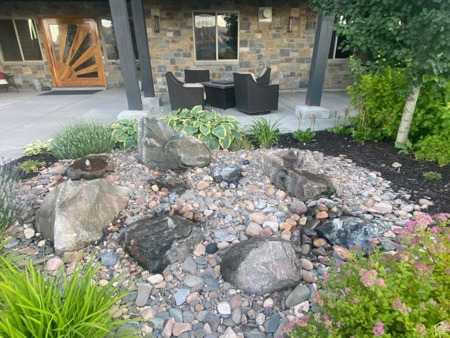 Outdoor living space and water feature at entry with custom Pivot Door. | Image 6