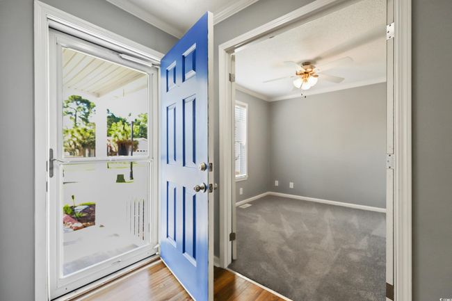 Foyer entrance with ornamental molding, baseboards, ceiling fan, and carpet floors | Image 6