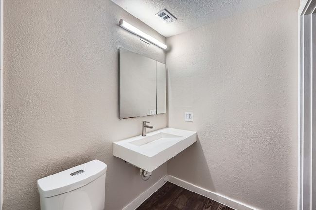 Bathroom with wood finished floors and a textured ceiling | Image 10