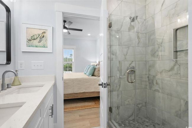 Full bath featuring ensuite bath, a stall shower, ornamental molding, double vanity, and light wood-type flooring | Image 22