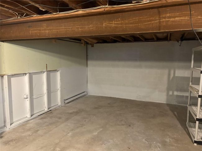 Unfinished basement with a baseboard radiator and concrete block wall | Image 18