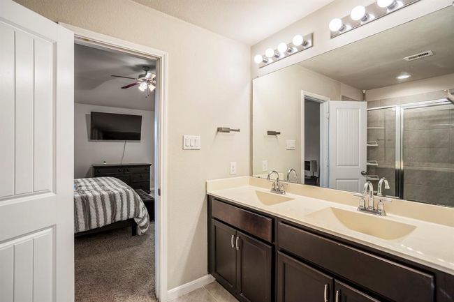 The bathroom has plenty of cabinet storage area under the sinks. | Image 25