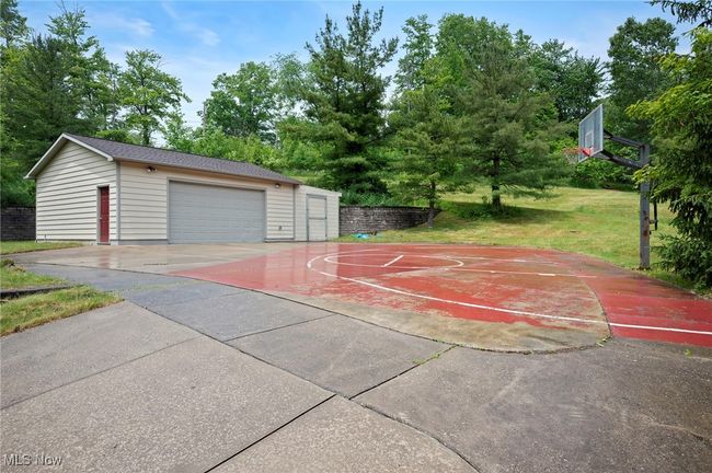 View of basketball court featuring a lawn, basketball court, and view of scattered trees | Image 45