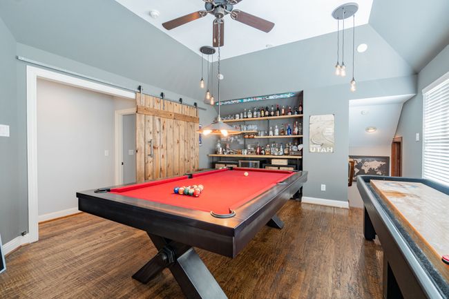 Recreation room with lofted ceiling, billiards, a bar, baseboards, and ceiling fan | Image 27