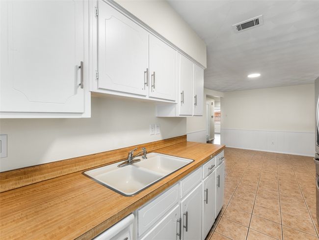 Kitchen featuring white cabinetry, sink, and light tile patterned floors | Image 15