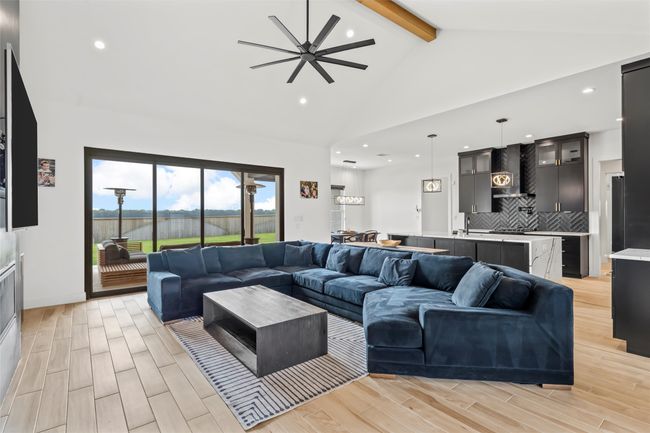 Living area featuring beam ceiling, a ceiling fan, wood finish floors, and recessed lighting | Image 7