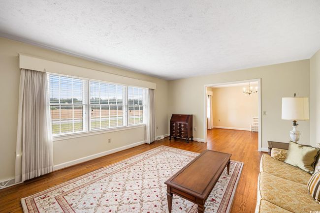 Living area featuring a chandelier, wood finished floors, baseboards, and a textured ceiling | Image 31