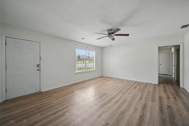 Unfurnished living room featuring ceiling fan, light wood finished floors, and baseboards | Image 15