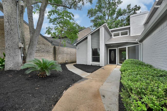 Fresh mulch and lush greenery frame the entry. | Image 4