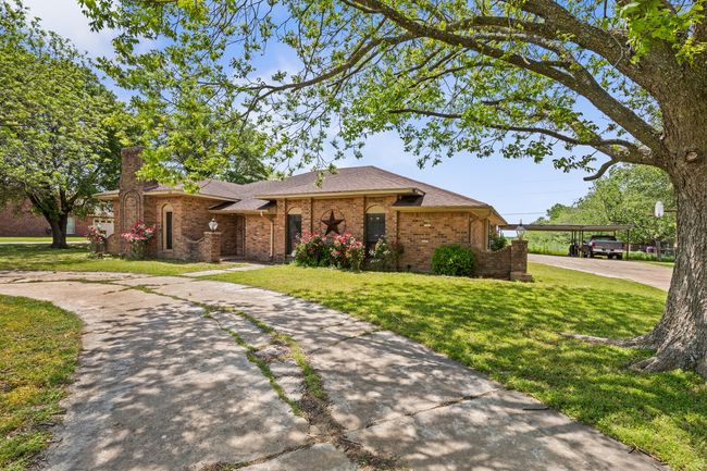 Single story home with brick siding, driveway, roof with shingles, and a front yard | Image 8