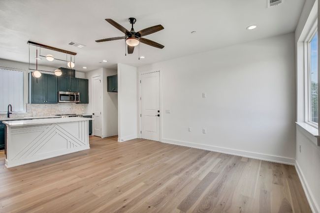 Kitchen with stainless steel microwave, backsplash, a ceiling fan, light countertops, and baseboards | Image 4