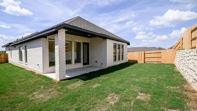 Rear view of property featuring brick siding, a fenced backyard, and a patio area | Image 13