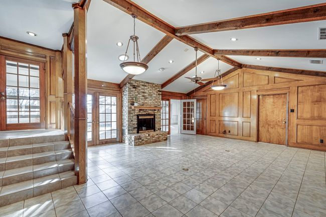 This family room showcases warmth and character with natural light streaming in. | Image 10