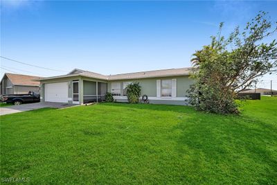 Ranch-style house featuring a garage, a front lawn, and central air condition unit | Image 3