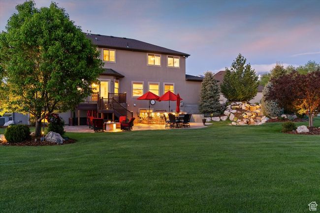 Back of property with a patio area, a lawn, stairs, and stucco siding | Image 68