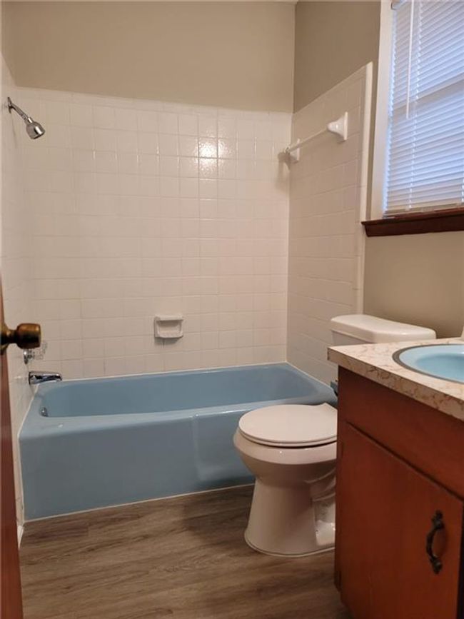 Bathroom with wood finished floors, vanity, and bathtub / shower combination | Image 9