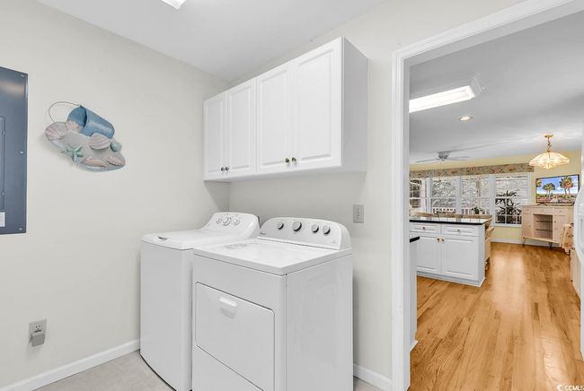 Laundry room with cabinet space, separate washer and dryer, light wood finished floors, recessed lighting, and a ceiling fan | Image 26
