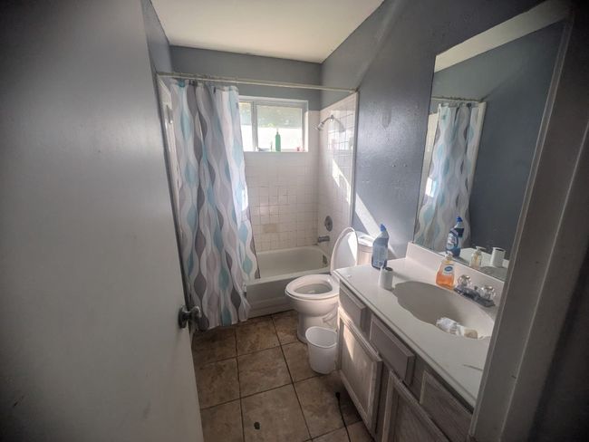 Full bath with shower / tub combo, vanity, and tile patterned floors | Image 10