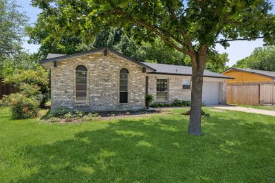 Ranch-style house with a garage and a front lawn | Image 1