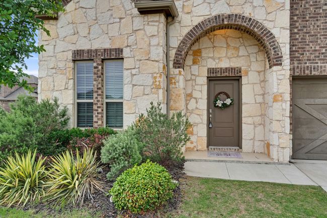 Property entrance featuring stone siding and a garage | Image 5