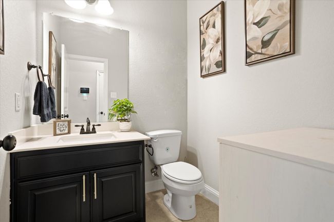 Half bathroom with toilet, tile patterned flooring, baseboards, and vanity | Image 24