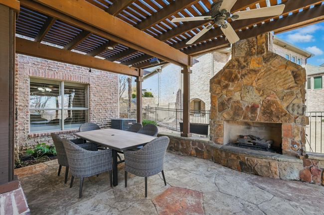 The outdoor living space includes a fireplace, covered and uncovered patio, bar seating for up to 15, a built in grill, and 2 refrigerators. | Image 34