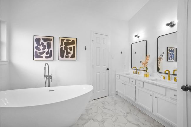 Bathroom with marble finish floors, double vanity, and a soaking tub | Image 15
