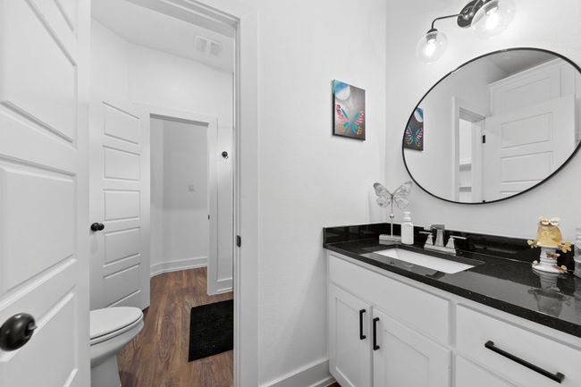Half bathroom featuring vanity, baseboards, visible vents, and wood finished floors | Image 28