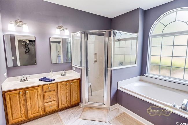 Full bathroom featuring a shower stall, a bath, and double vanity | Image 26