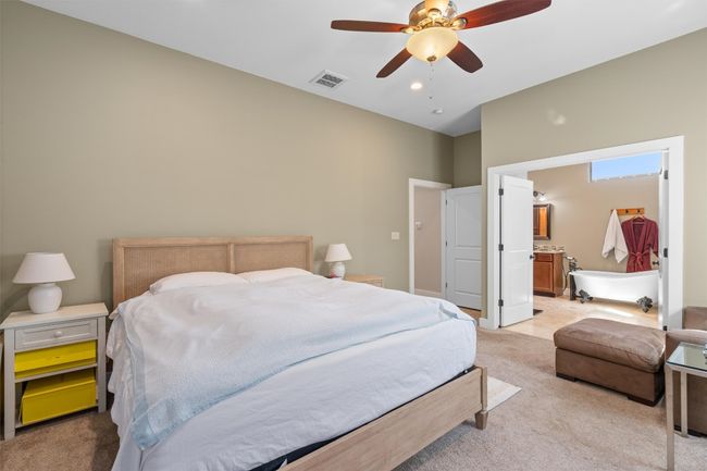 Bedroom featuring light carpet, visible vents, ensuite bathroom, and a ceiling fan | Image 14