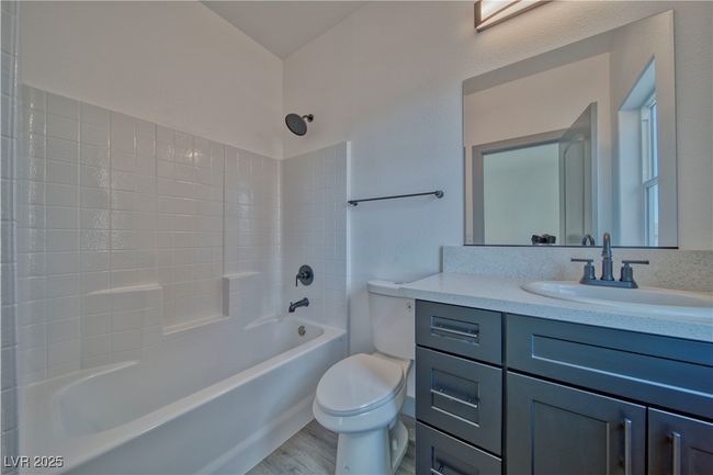 Primary Bathroom featuring shower / bath combination, vanity, toilet, and elegant vinyl floors. **These are model photos, light fixtures subject to change.** | Image 17