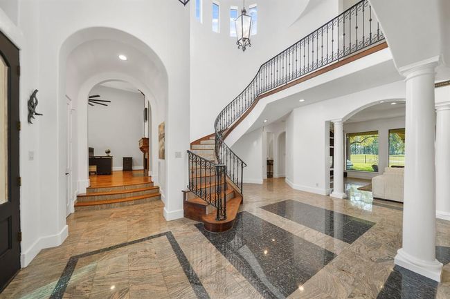 Accessible from the foyer and opposite the formal dining room is an elevated study complete with an arched entry. | Image 6