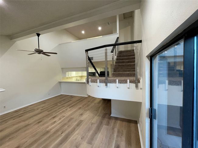 Unfurnished living room featuring high vaulted ceiling, hardwood / wood-style flooring, and ceiling fan | Image 10