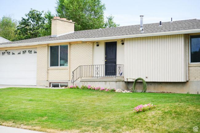 Ranch-style home with a front yard, a garage, a chimney, and brick siding | Image 29