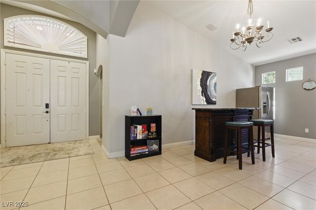 Foyer entrance with a chandelier, visible vents, baseboards, and light tile patterned floors | Image 4