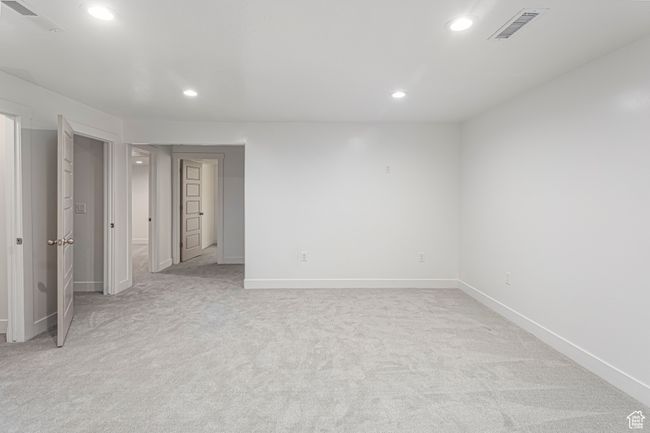 Unfurnished bedroom with light colored carpet, visible vents, recessed lighting, and baseboards | Image 36