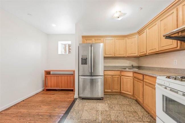Kitchen with stainless steel refrigerator with ice dispenser, white range with gas stovetop, light brown cabinets, and recessed lighting | Image 5