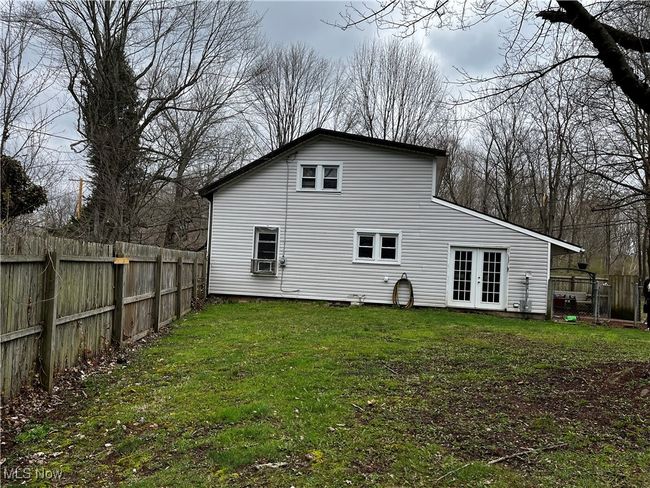 Rear view of property with a yard, french doors, fence, and cooling unit | Image 19