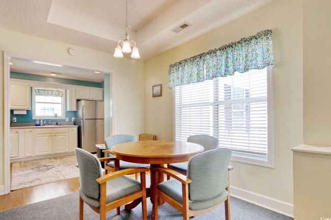 Dining area with a chandelier, wood finished floors, and a tray ceiling | Image 9