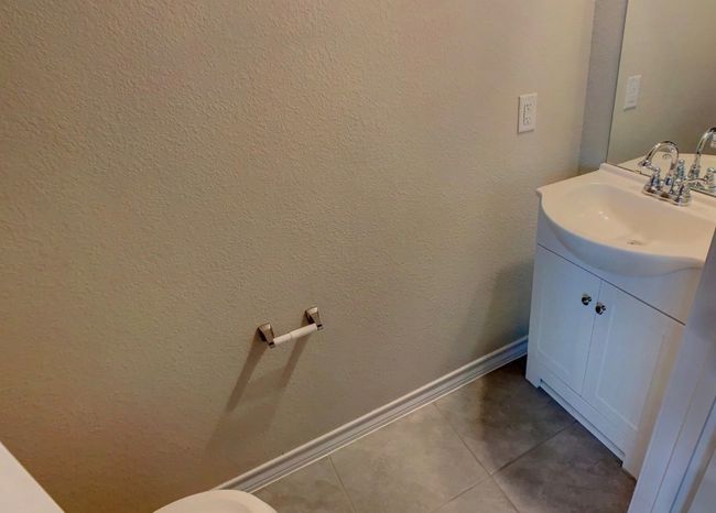 Half bathroom with baseboards, tile patterned floors, and vanity | Image 25