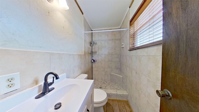 Full bath featuring toilet, tile walls, tiled shower, vanity, and wood finished​​‌​​​​‌​​‌‌​‌‌​​​‌‌​​‌‌​‌​​​​​‌ floors | Image 13