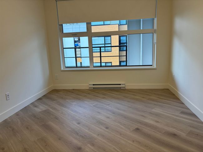 Unfurnished room featuring a baseboard radiator and wood finished floors | Image 15
