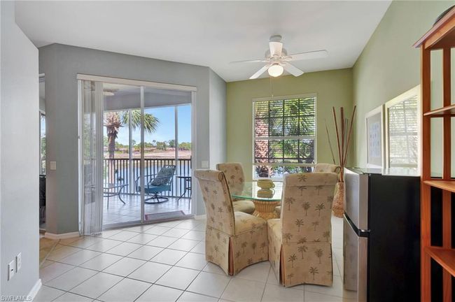 Sunroom featuring a water view, ceiling fan, and lofted ceiling | Image 17