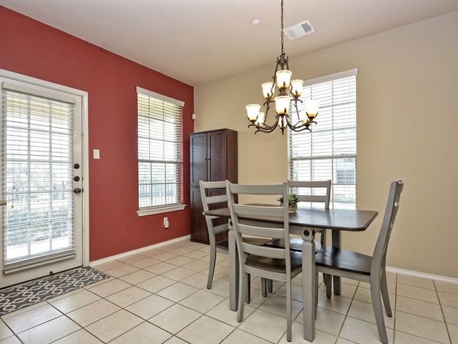 Dining area with a chandelier, baseboards, and light tile patterned flooring | Image 8
