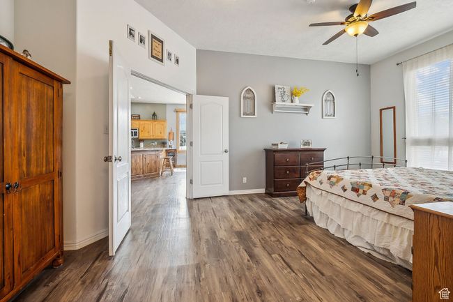 Bedroom featuring ceiling fan, baseboards, and dark wood-type flooring | Image 22