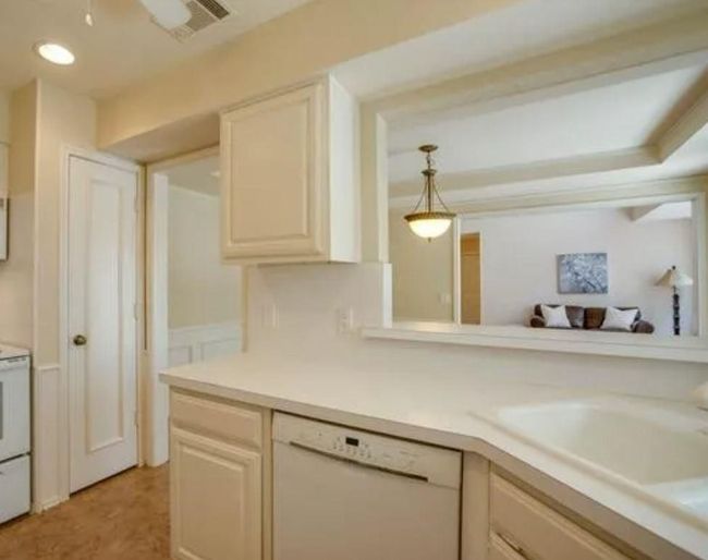 Kitchen featuring white appliances, light countertops, a sink, decorative light fixtures, and recessed lighting | Image 11