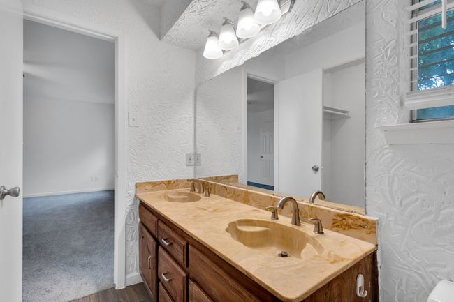 Bathroom with double vanity, a sink, and wood finished floors | Image 23